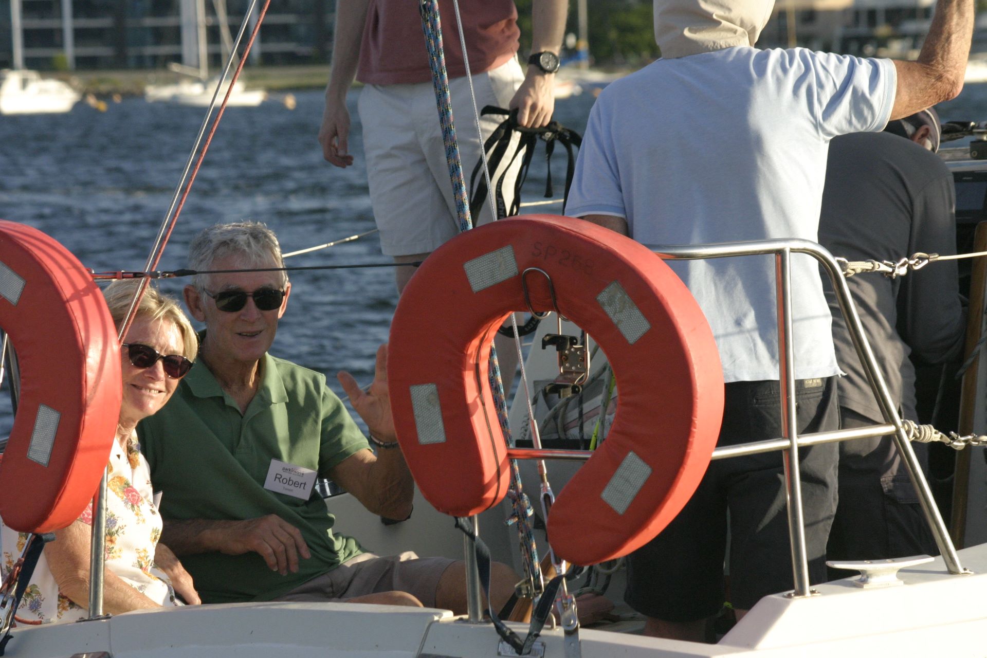 A man and lady smile as they ride in a sailing boat.